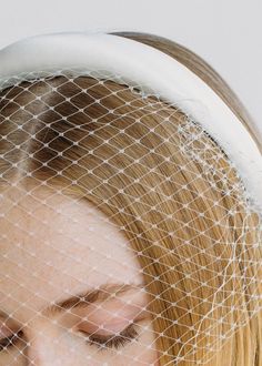 a woman with blonde hair wearing a veil over her head and looking at the camera