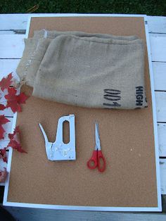 a pair of scissors sitting on top of a piece of paper next to some leaves