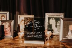 a wooden table topped with pictures and framed photos next to candles on top of it