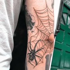 a man with a spider web tattoo on his arm