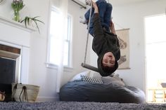 a man is upside down on the floor with his feet in the air while holding onto a child's leg