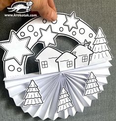 someone is holding up some paper decorations to make it look like they are in the shape of a house