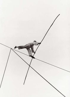 an old photo of a man on skis in the air with poles attached to him