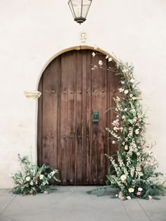 a wooden door with vines and flowers around it