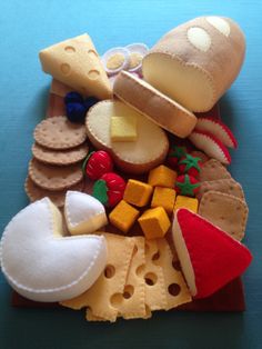 an assortment of cheese and crackers on a blue surface