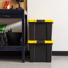 two black and yellow bins sitting on top of a shelf next to each other