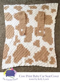 a brown and white crocheted baby blanket on top of a carpet with the words cow print baby car seat cover