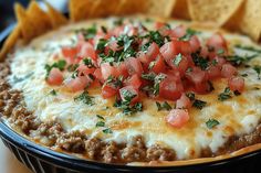 a close up of a bowl of food with tortilla chips