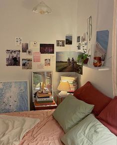 a bed room with a neatly made bed and many pictures on the wall above it