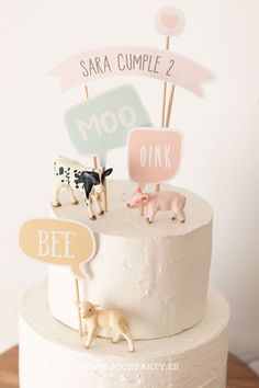 there is a cake that has animals on the top and two signs in the middle