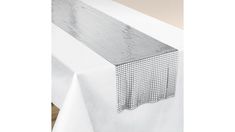 a white table cloth with a metal mesh design on it's edge and the top