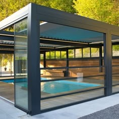 a glass enclosed swimming pool in front of a house