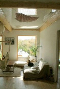 a living room filled with furniture and a hammock hanging from the ceiling