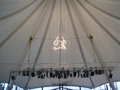 the inside of a large white tent with lights hanging from it