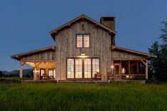 a large wooden house sitting on top of a lush green field