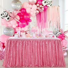 a table topped with lots of pink and white balloons