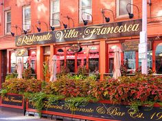 the outside of a restaurant with plants growing out of it's windows