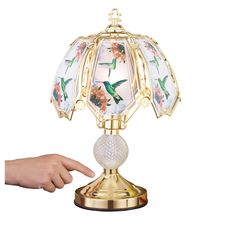 a hand is pointing at a lamp that has hummings on it