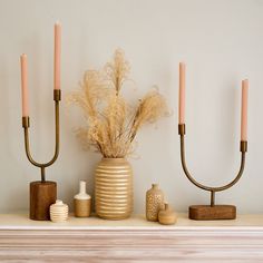 some candles are sitting on top of a mantle