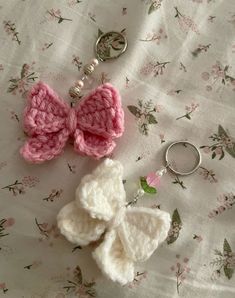 two crocheted hearts and a keychain laying on a flowered cloth