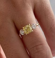 a woman's hand with a yellow and white diamond ring