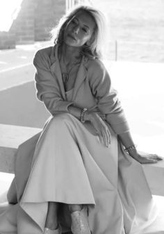 a woman sitting on top of a wooden bench