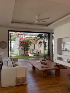 a living room filled with furniture and a wooden table in front of a sliding glass door