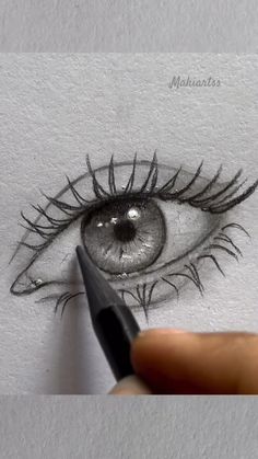 someone is drawing an eye with a pencil