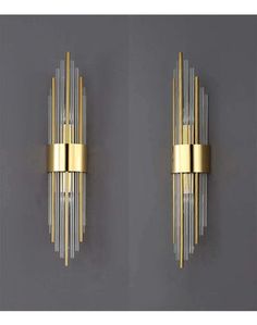 two wall sconces in gold and clear glass, each with an unusual design