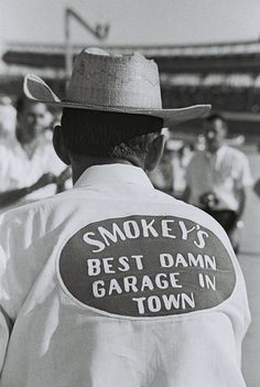 black and white photograph of man wearing smokey's best damn garage in town shirt