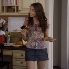 a woman standing in a kitchen holding food