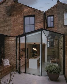 a house that has some plants in front of it and windows on the outside wall