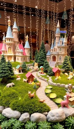 a display with fake trees, houses and animals in the middle of grass covered ground