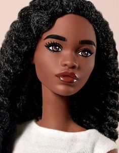 a close up of a doll with black hair and big lashes on her face, wearing a white sweater