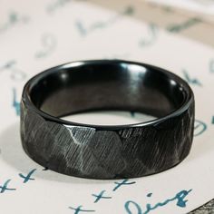 a black ring sitting on top of a piece of paper