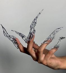 a person's hand holding something in the air with their fingers extended up to it