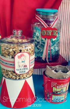 two large jars filled with popcorn sitting on top of a blue table next to each other