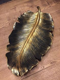 a gold leaf shaped dish on a wooden table