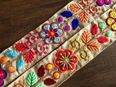 an embroidered ribbon with colorful flowers and leaves on it