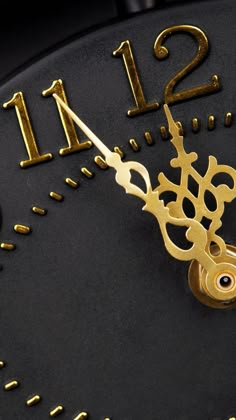 a close up of a clock face with gold numbers