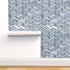 a wallpaper with blue and white herringbones on it in an empty room