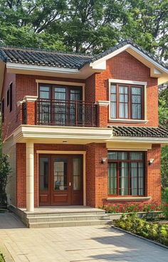 a red brick house with two story windows and balconies on the second floor