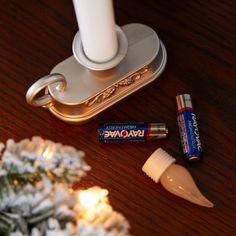 three different types of toothpaste on a wooden table next to a candle holder