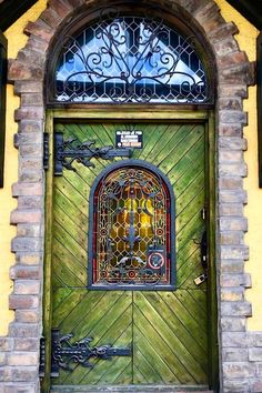 the front door is made of wood and has wrought iron work on it's sides