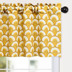 a yellow and white window curtain with an art deco design on it's valance