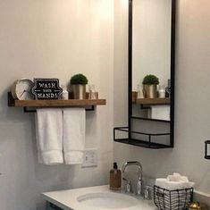 a bathroom with a sink, mirror and shelf above the toilet is decorated in black and white