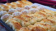 a tray filled with rolls covered in cheese