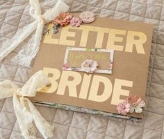 an open book with flowers on it sitting on top of a bed