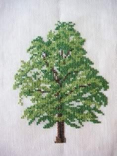 a cross stitched picture of a green tree