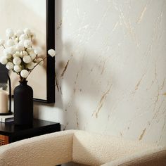 a vase filled with white flowers sitting on top of a table next to a mirror